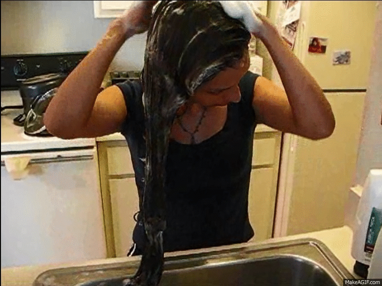 Housewife washes hair kiitchen sink